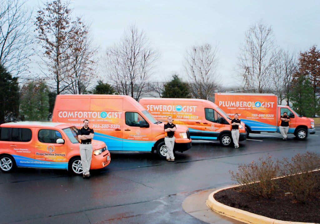 Side view of 4 Home Service Doctors work trucks and vans in a parking lot